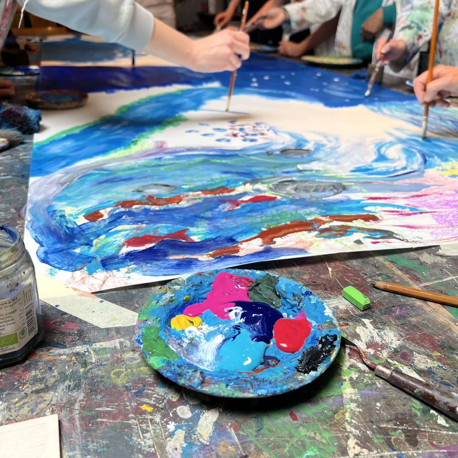 Schüler arbeiten mit Acrylfarben